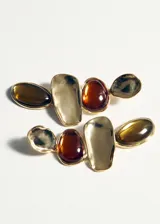 Aros colgantes formados por piezas metálicas doradas de diseño irregular y piedras de resina en tonos ámbar y marrón oscuro.