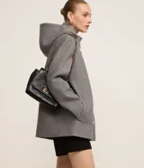 Saco corto negro de polivelour con capucha, cuello alto con cremallera, abotonado delantero cruzado, bolsillos delanteros y mangas largas.