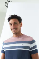 Remera de hombre a rayas horizontales en tonos rosa, blanco y azul marino. Tiene logo bordado en el pecho y corte regular.