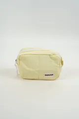 Neceser pequeño de color amarillo claro, con diseño acolchado y cierre superior blanco. Incluye una etiqueta con el logo de la marca Indian en el frente.