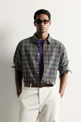 Camisa relaxed fit de algodón con diseño de cuadros en tonos azules, amarillos y naranjas. Cuenta con cuello solapa abotonada, manga larga con puño abotonado y cierre frontal de botones.