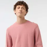 Sweater de punto con textura nido de abeja, color rosado, con cuello redondo y mangas largas.