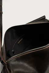 Bandolera XL de piel color marrón oscuro con acabado desgastado, compartimento principal con solapa y cremallera, y correa de hombro ajustable con hebilla.