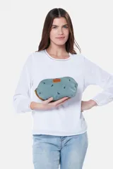 Estuche necessaire de lona tipo canvas color crudo con estampado de flores en color lila. Tiene cierre superior con tirador de cuero marrón y manija lateral de cuero marrón.