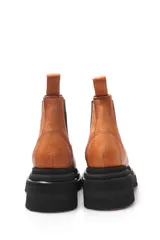 Borcego negro de cuero liso con elásticos laterales y suela de goma.