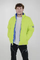 Campera puffer reversible de corte holgado, con cuello alto y cierre frontal. Un lado es de color azul vibrante con detalles en verde lima en el cierre y el interior, y el otro lado es de color negro.
