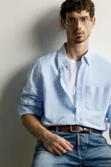 Camisa regular fit celeste confeccionada en mezcla de lino y algodón, con cuello abotonado, manga larga, bolsillo frontal en el pecho y cierre de botonadura.