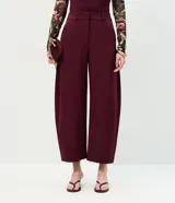 Pantalón de sastrería color bordó, con modelaje barrel, cintura estructurada, pasadores para cinturón y piernas amplias con ruedo levemente afinado.