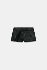 Shorts mini de tiro bajo confeccionados en tejido jacquard con diseño floral en tono negro. Cuenta con forro interior combinado a tono y cierre frontal con cremallera, botón interior y gancho metálico.