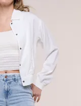 Camperita bomber de lyocell con textura suave, color azul marino, cuello camisero, cierre frontal con botones a presión, bolsillos laterales con solapa, mangas largas con puños elásticos y pretina fruncida en el ruedo.