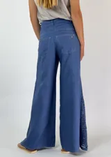 Pantalón de lino color beige, corte palazzo, con detalle de crochet en el lateral inferior.