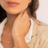 Conjunto compuesto por cadena fina y dije circular con circonia central engastada en oro 18k.
