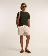 Bermuda masculina de corte recto, confeccionada en una mezcla de algodón y lino. Presenta cintura elástica con cordón de ajuste, bolsillos laterales y un diseño liso sin estampados.