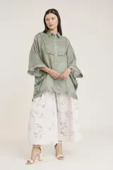 Camisa de manga ancha, color verde salvia, con cuello camisero y cierre frontal de botones. Presenta detalles de pespunte decorativo en el canesú frontal.