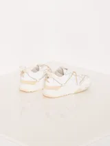 Zapatilla urbana color blanco con detalles en cuero color crema, con cordones y suela de goma.