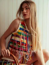 Top de crochet sin mangas, con cuello a la base y diseño multicolor a rayas adornado con múltiples flecos colgantes.
