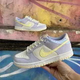 Championes Nike Dunk Low SE modelo Easter, con diseño en tonos pastel que combina paneles de cuero en lila y crema, con detalles de estampado de cuadros vichy en el talón y un swoosh lateral en amarillo pálido. Presenta suela de goma en tono crema.