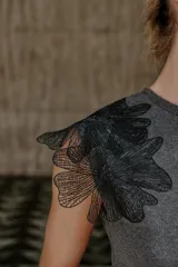 Top gris de cuello redondo y sin mangas, con detalle de flores negras de organza en los hombros.