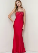 Vestido largo de fiesta color rojo, corte sirena, con escote strapless y detalle de pedrería brillante en el busto.