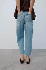 Jeans de tiro medio con diseño de volumen crop, confeccionados en denim de lavado azul clásico, con cinco bolsillos y costuras decorativas laterales.