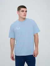 Remera Umbro de manga corta, color celeste, con cuello redondo y el logo de la marca bordado en el pecho.