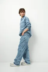 Pantalón de jean azul claro, de corte oversized y tiro bajo, con bolsillos traseros grandes.