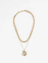Collar dorado de acero quirúrgico hipoalergénico, con tres cadenas de diferentes grosores y un dije con forma de espiral.