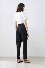 Pantalón de vestir color beige, de corte recto, con pinzas, bolsillos laterales y cinturón con hebilla forrada.