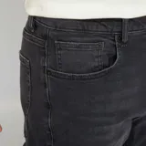 Jean slim de hombre color negro, con 5 bolsillos y cierre de botón y cremallera.