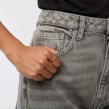 Pantalón de jean gris, de corte recto, con cintura alta y botamangas anchas con dobladillo.