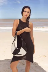 Cartera negra de cuero con forma de medialuna y tachas en zigzag.