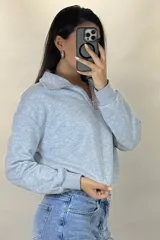 Buzo deportivo color blanco con cuello polo y cierre frontal parcial. Presenta mangas largas con puños elásticos y ruedo ajustable con cordón elástico.
