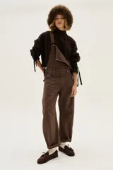 Mocasín de gamuza color bordó con detalle de flecos, cordones y tachas metálicas en la parte superior.