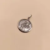 Medalla circular de plata 925 con relieve de Santa Rita de Casia, con argolla superior para cadena.