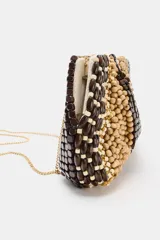 Bolso tipo pouch confeccionado completamente con cuentas de madera en tonos marrón, beige y tostado, formando un patrón abstracto. Cuenta con una correa fina de cadena dorada desmontable y cierre superior con cremallera.