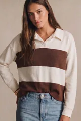 Sweater de tejido de punto con diseño a rayas horizontales en color crema y marrón. Presenta cuello tipo polo con cierre frontal de botones ocultos, mangas largas y un corte oversize.