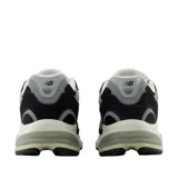 Championes urbanos New Balance, color negro con detalles en gris y blanco, confeccionados con capellada de malla y superposiciones de gamuza, con la característica 'N' en los laterales y entresuela amortiguada.