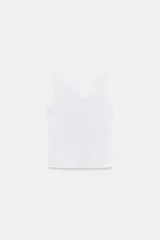 Camiseta blanca de tejido rib, corte ajustado (slim fit), con escote cruzado asimétrico y tirantes anchos.