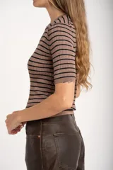 Sweater de punto acanalado color beige con hilos metalizados, de manga corta y escote redondo, corte ajustado al cuerpo.