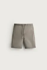 Bermuda regular fit de tejido elástico color blanco, con cintura elástica ajustable mediante cordón, bolsillos delanteros y bolsillos traseros de vivo.