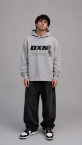 Hoodie gris de corte holgado con capucha y bolsillo frontal, estampado con el logo DXN y un gráfico de silueta con texto motivacional en color negro.
