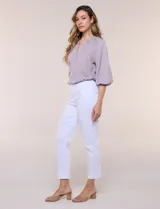 Pantalón color beige de corte entallado y largo cropped, confeccionado en tejido de punto con elasticidad técnica. Cuenta con pretina ancha y plana, bolsillos simulados al frente y bolsillos tipo ojal en la parte posterior.