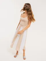 Falda midi color beige con paneles verticales blancos.