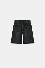 Bermuda de denim color negro gastado, de tiro medio y corte relaxed con bajo desflecado. Cuenta con trabillas en la cintura, diseño de cinco bolsillos y cierre frontal con cremallera y botón metálico.