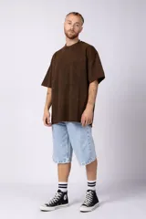 Remeron de algodón rústico con efecto de lavado gastado, corte oversize, cuello redondo y mangas cortas con terminaciones al corte.