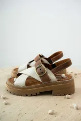 Sandalias de cuero color tostado y blanco, con plataforma track y hebilla metálica.