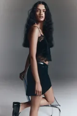 Pollera mini negra entallada de corte evasé, con cierre oculto y corchete en un lateral.