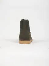 Bota tipo leñadora color verde oliva, con cordones al tono, cuello de pana acanalada y suela de goma dentada en color tostado.