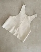 Chaleco color crema de cuero agamuzado con espalda cruzada.