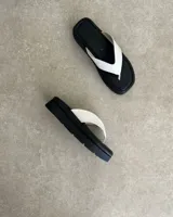 Ojota de plataforma color negro con tira ancha en forma de V de cuero vegano blanco.